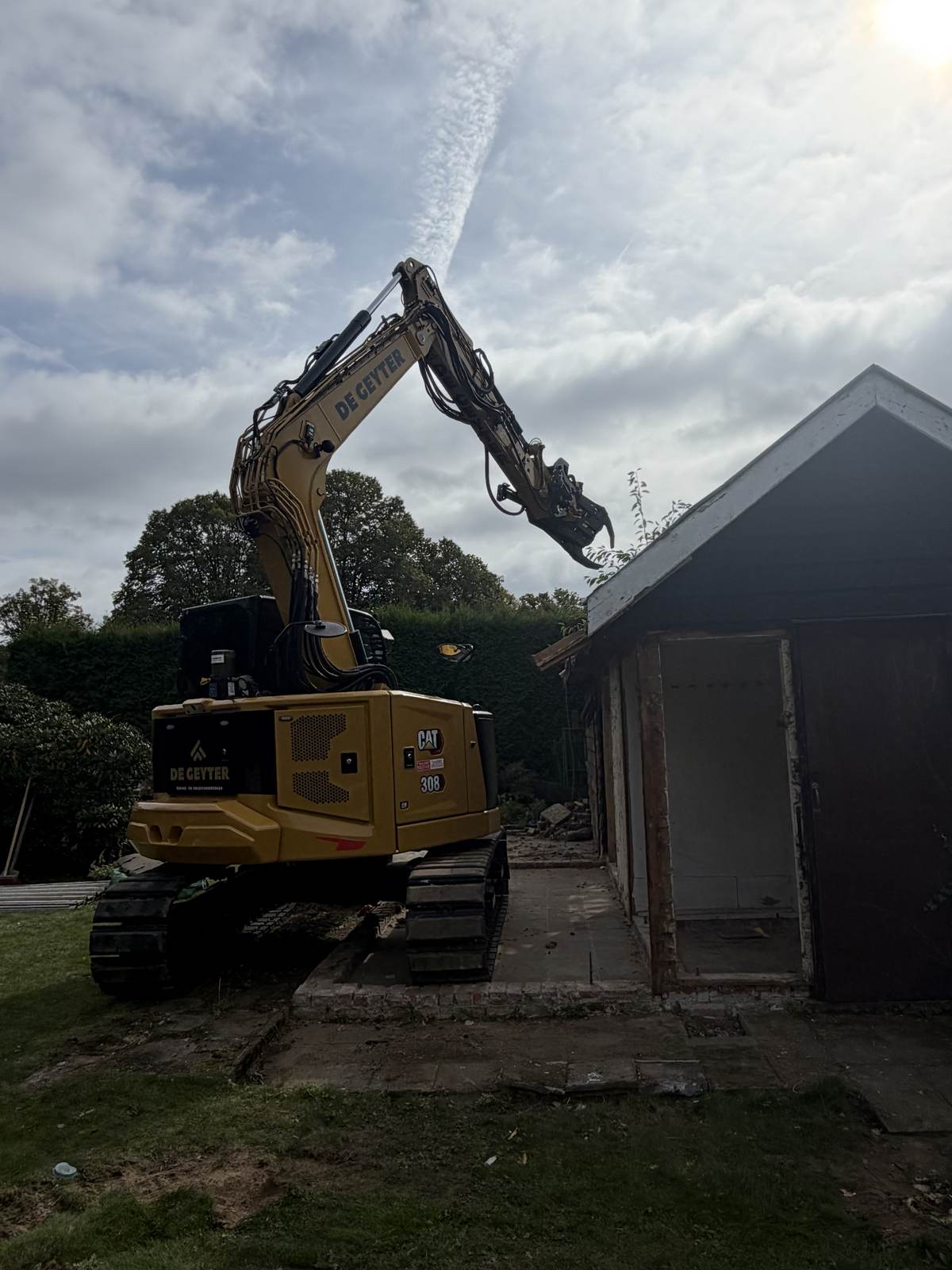 De CAT 308 breekt een schuur af met de sorteergrijper