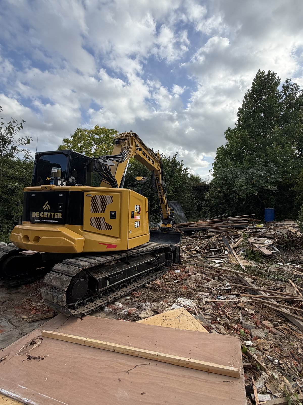 CAT 308 tussen het puin van een afgebroken schuur