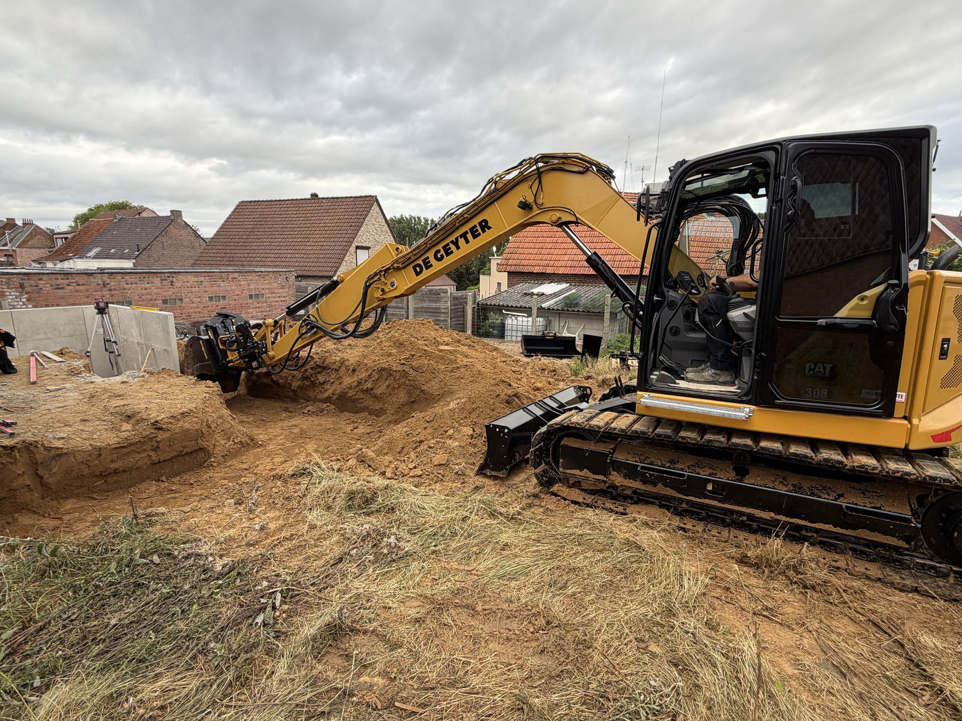 CAT 308 met tiltrotator in een zandwerf