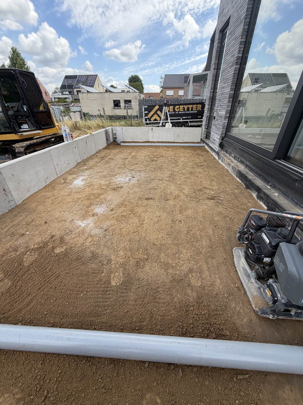 Uitgegraven en verdichte terraskoffer naast een woning